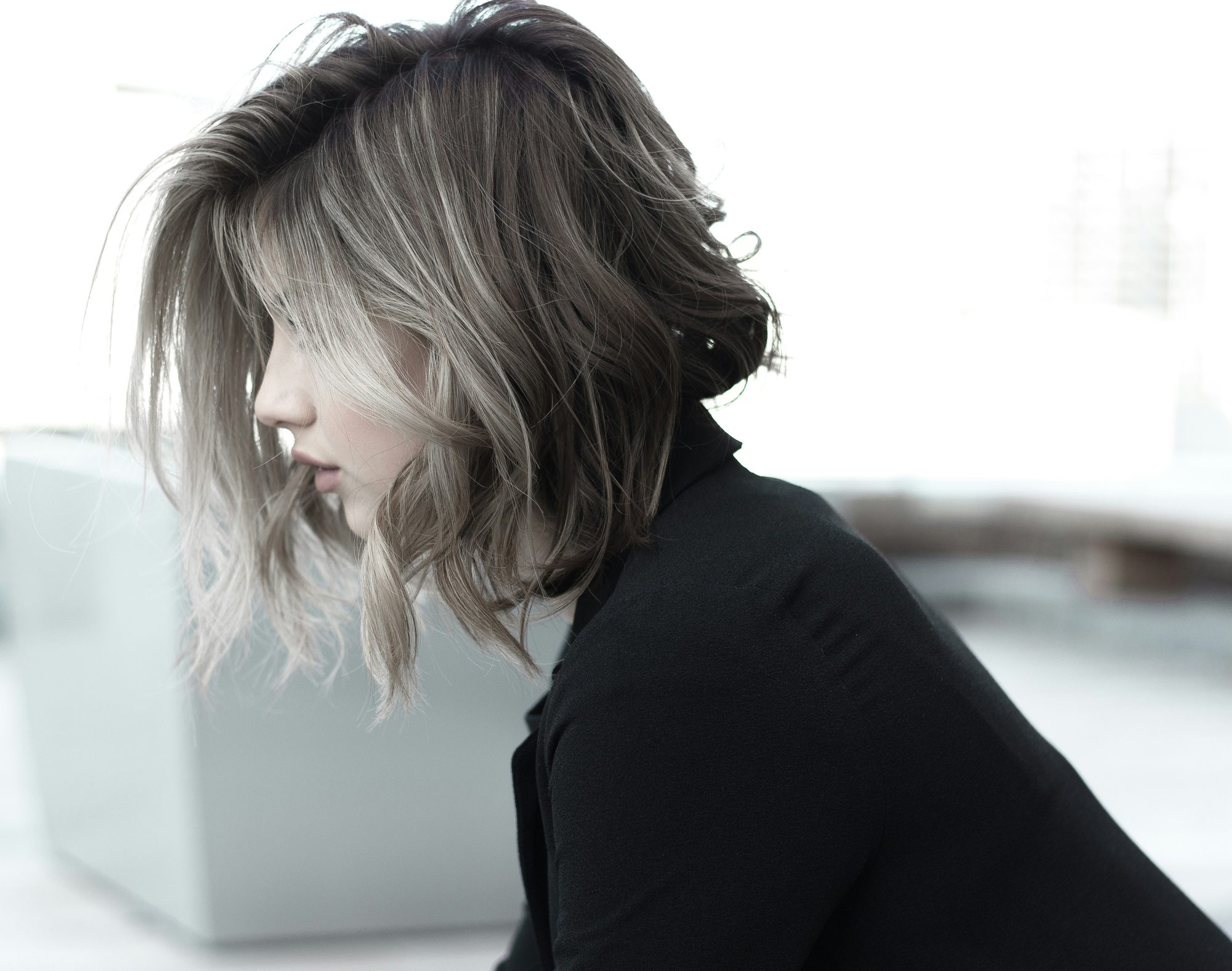 Mujer de perfil con corte bob ondulado en tonos cenizos
