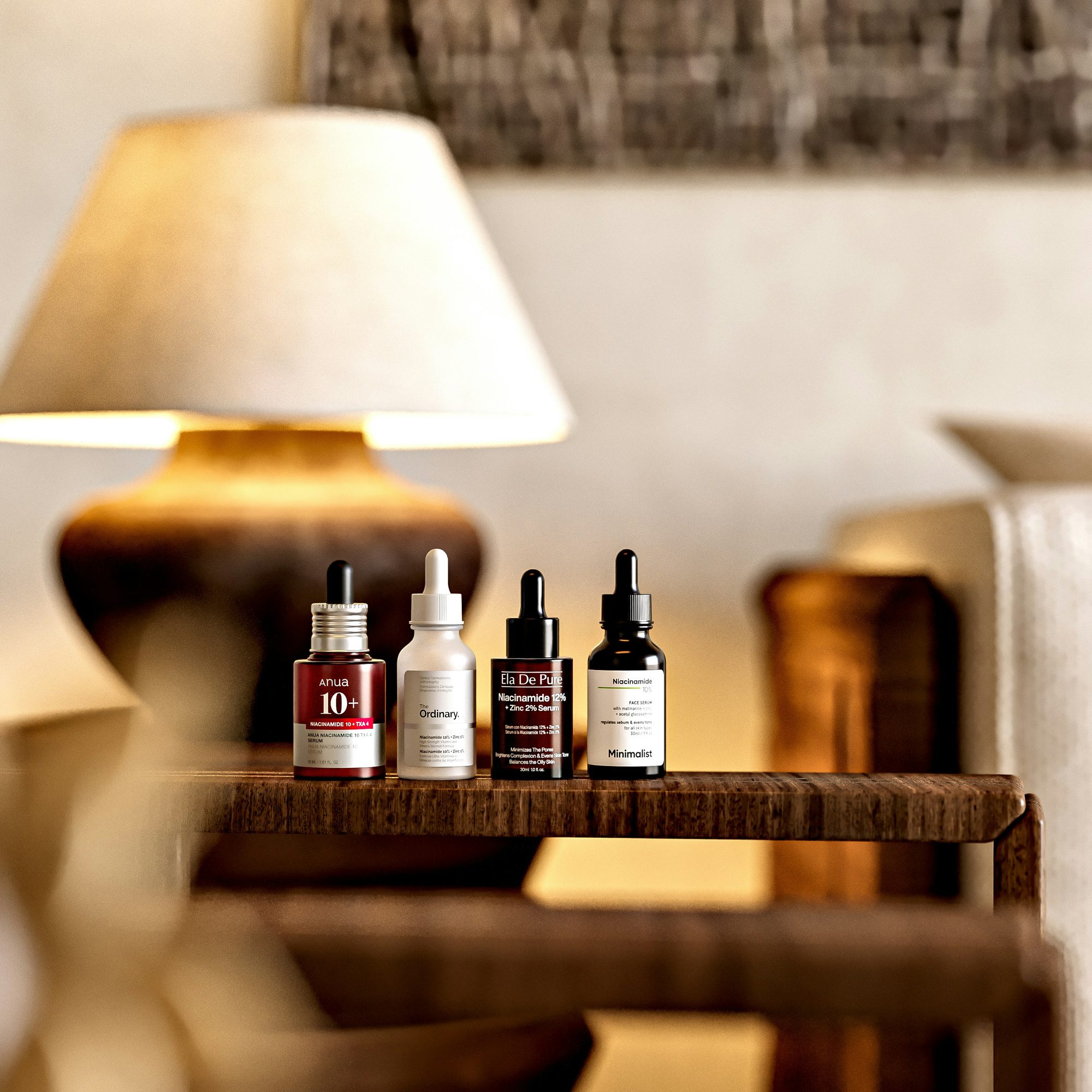 Frascos de sérum sobre una mesa de madera junto a una lámpara encendida
