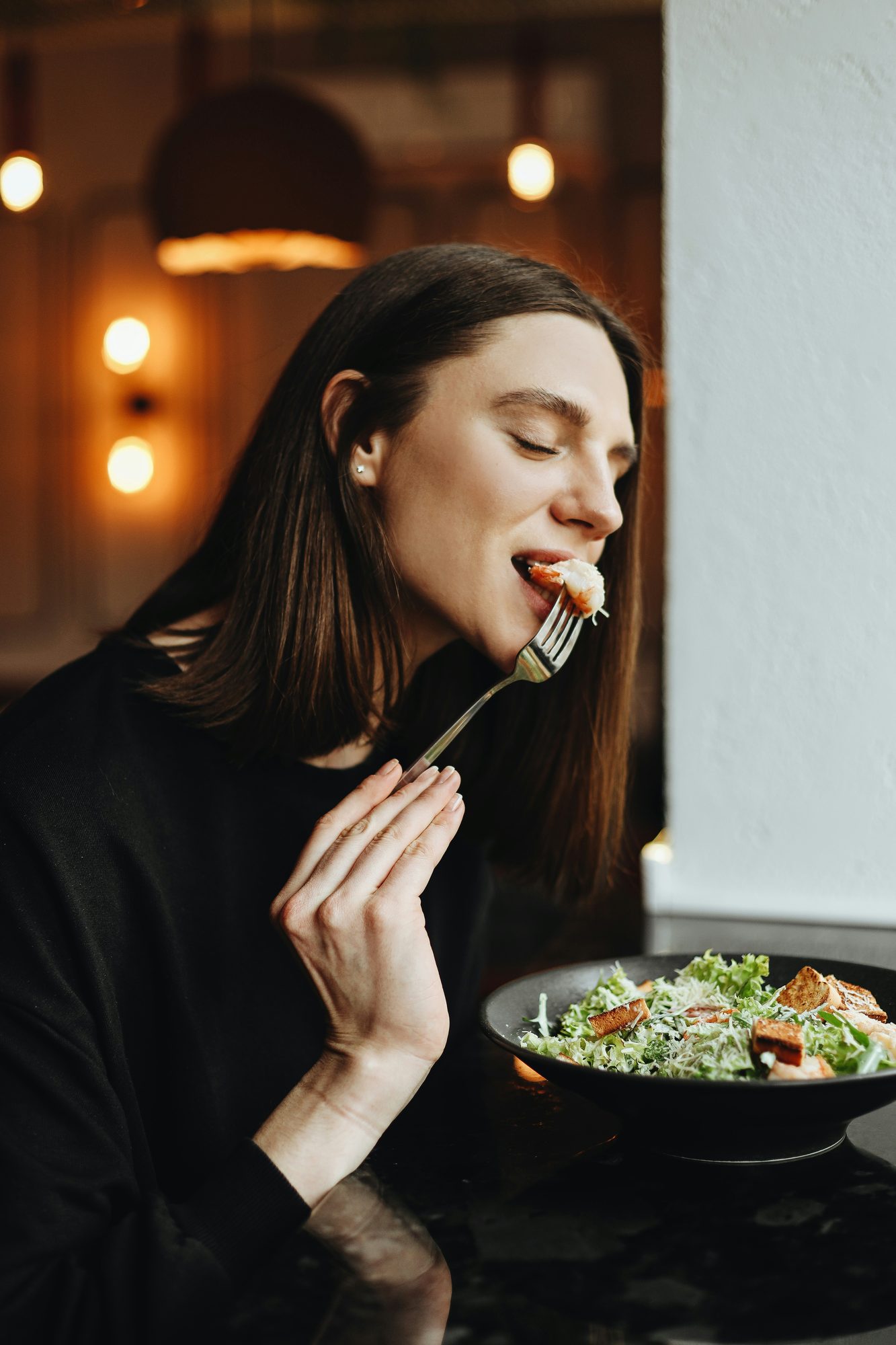 Mujer disfrutando un plato de ensalada en un restaurante