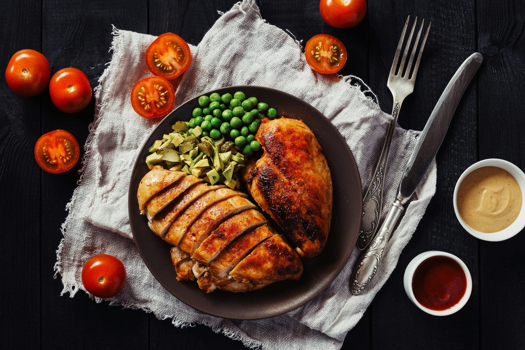 Plato de pollo asado con guisantes y tomates cherry