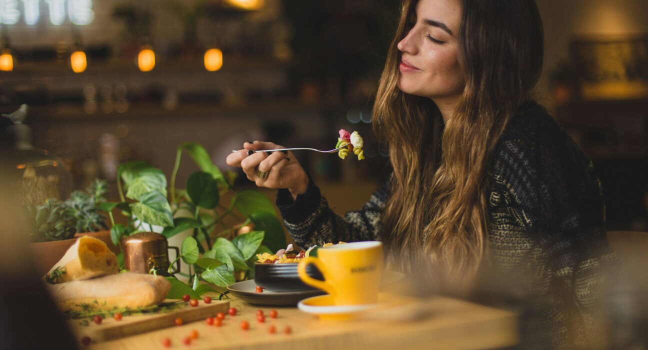 Mujer sonriente comiendo en una cafetería