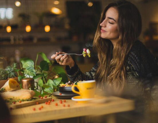 Mujer sonriente comiendo en una cafetería