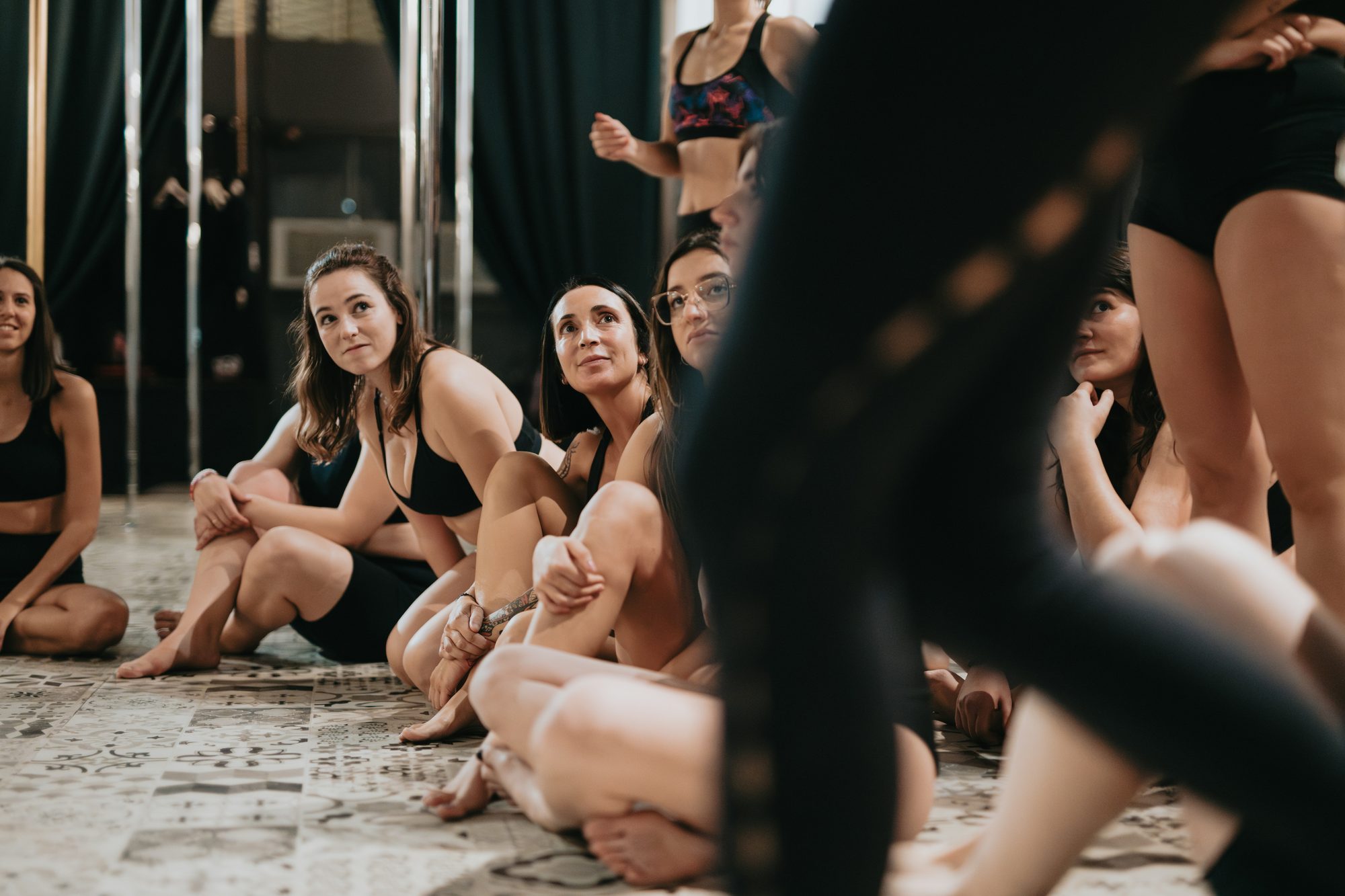 Grupo de mujeres descansando sentadas en el suelo de un estudio