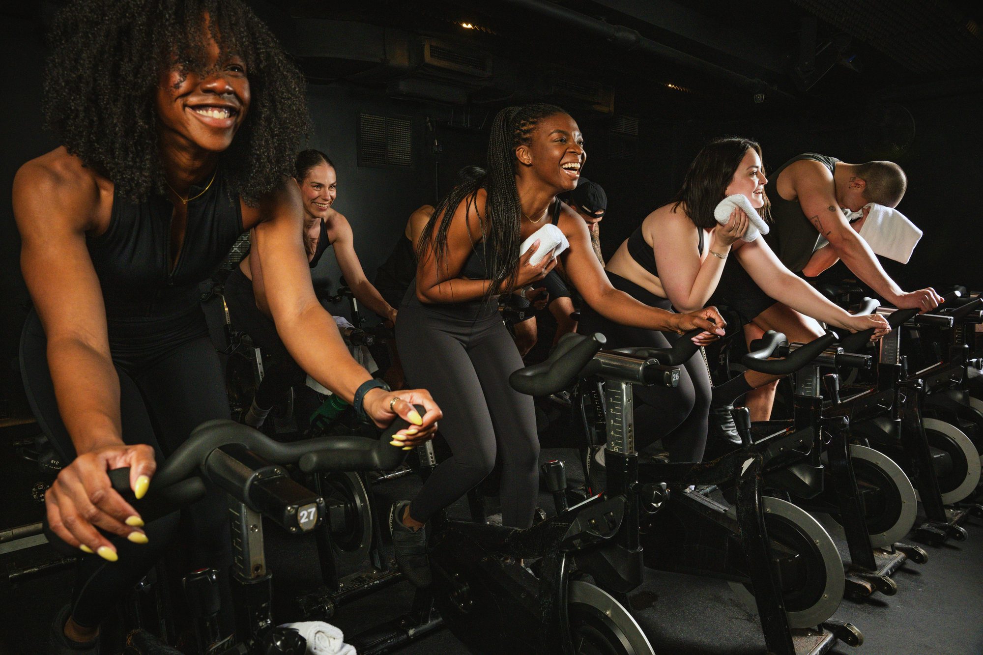 Mujeres sonrientes en una clase de indoor cycling