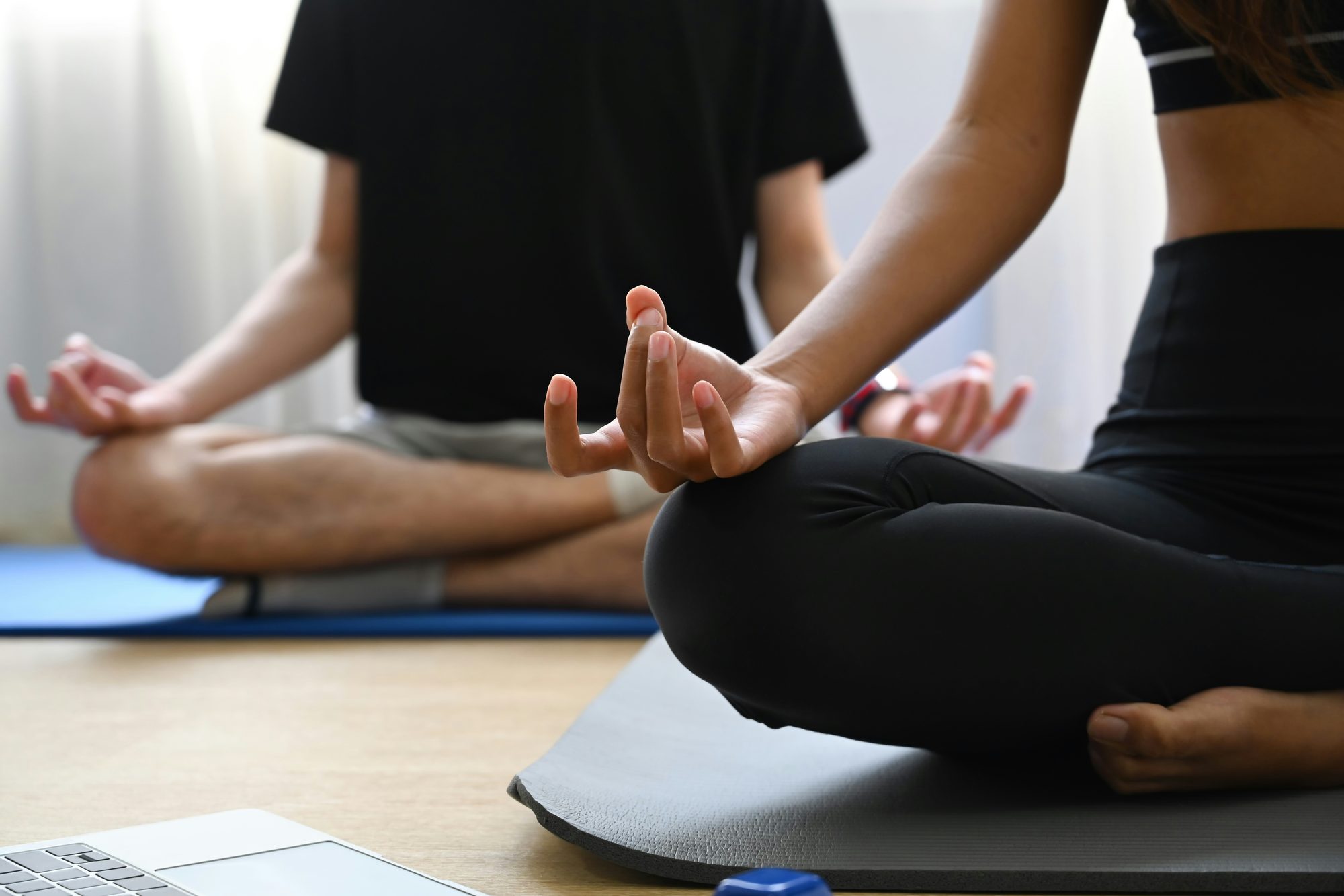 Dos personas meditando con las piernas cruzadas