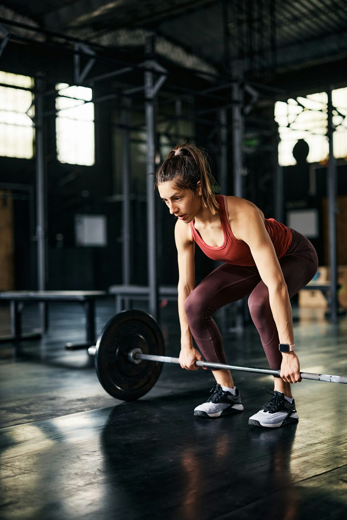 Mujer levantando una barra con discos en un gimnasio